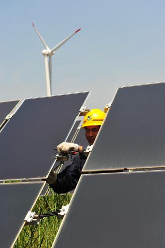 8月1日,在江苏大丰的薄膜太阳能电站,工人悉心维护非晶硅薄膜光伏组件。新华社发(周古凯 摄)
